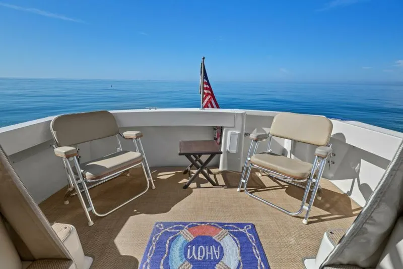 Whattakeeper Yacht Photos Pics 2006 Mainship 34 Rum Runner II deck with chairs, table, and ocean view.