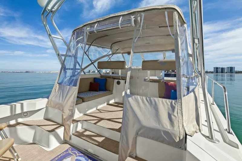 Whattakeeper Yacht Photos Pics 2006 Mainship 34 Rum Runner II boat with covered seating area on calm water.