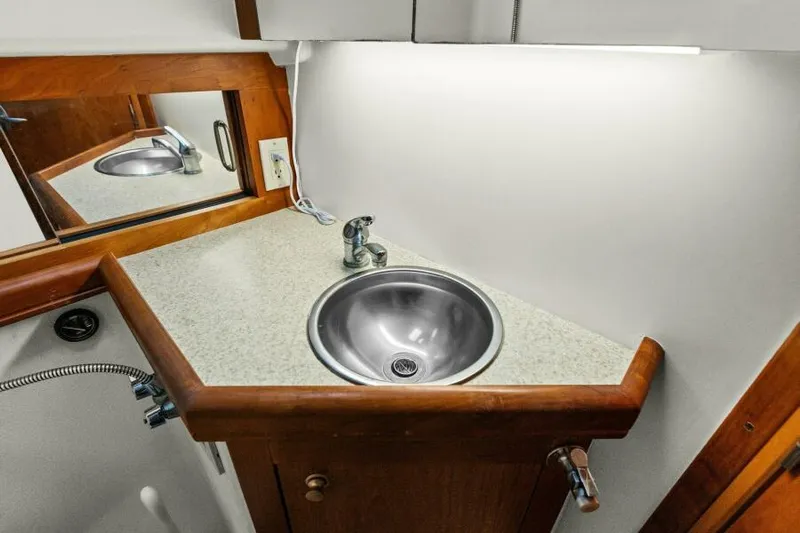 Whattakeeper Yacht Photos Pics 2006 Mainship 34 Rum Runner II bathroom sink with mirror and wooden accents.