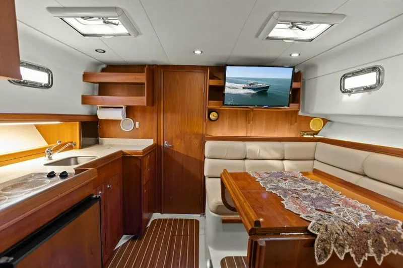 Whattakeeper Yacht Photos Pics Interior of 2006 Mainship 34 Rum Runner II with kitchen and dining area.