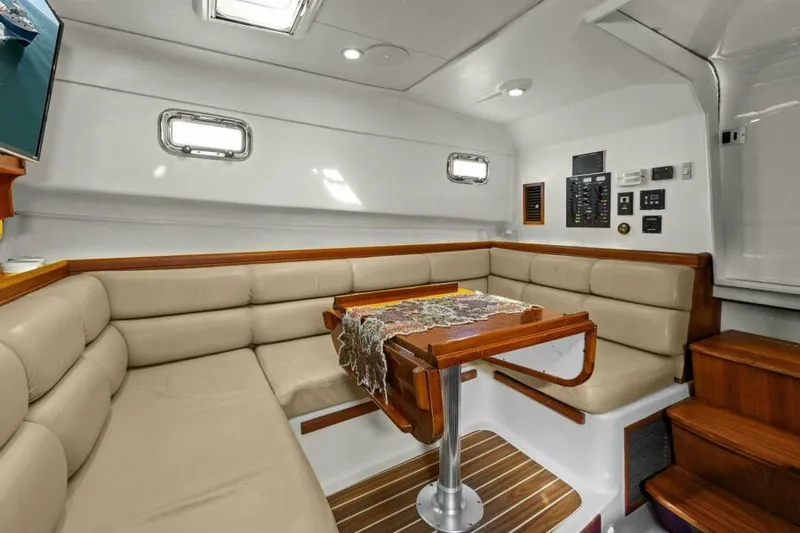 Whattakeeper Yacht Photos Pics Luxurious interior of 2006 Mainship 34 Rum Runner II with beige seating and wooden accents.