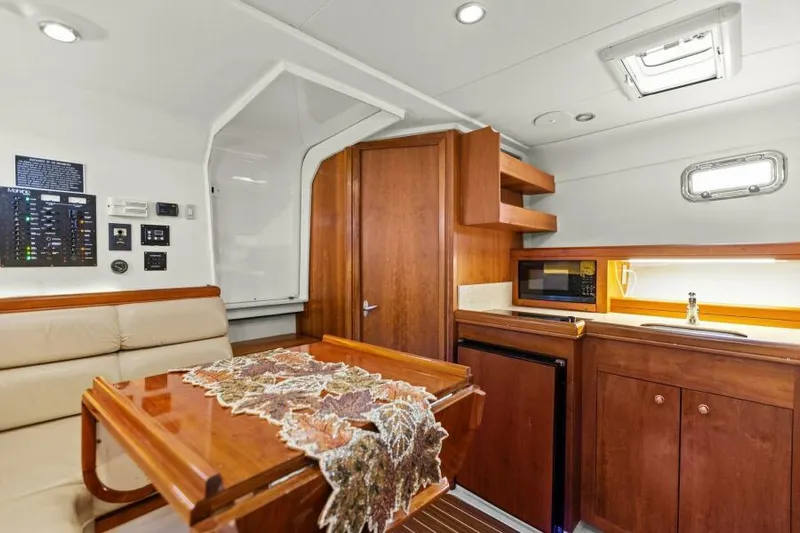 Whattakeeper Yacht Photos Pics Interior of 2006 Mainship 34 Rum Runner II with kitchenette and dining area.