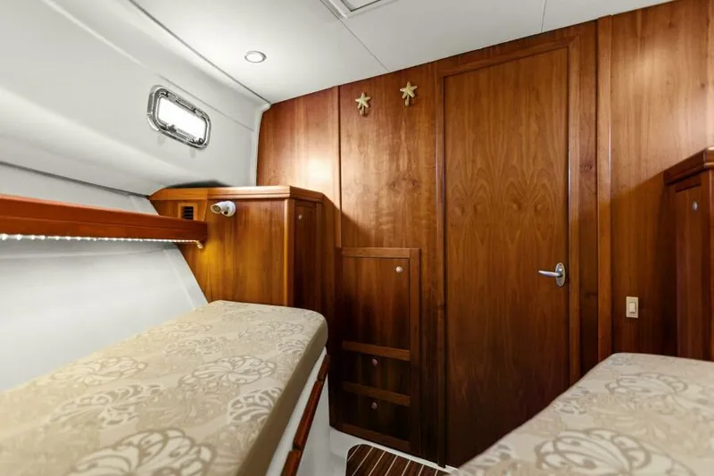 Whattakeeper Yacht Photos Pics Interior cabin of 2006 Mainship 34 Rum Runner II with wooden finishes and twin beds.
