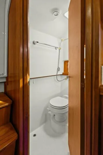 Whattakeeper Yacht Photos Pics 2006 Mainship 34 Rum Runner II bathroom with wooden door and white interior.