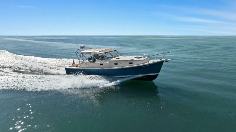 Whattakeeper Yacht Photos Pics 2006 Mainship 34 Rum Runner II cruising on calm ocean waters.