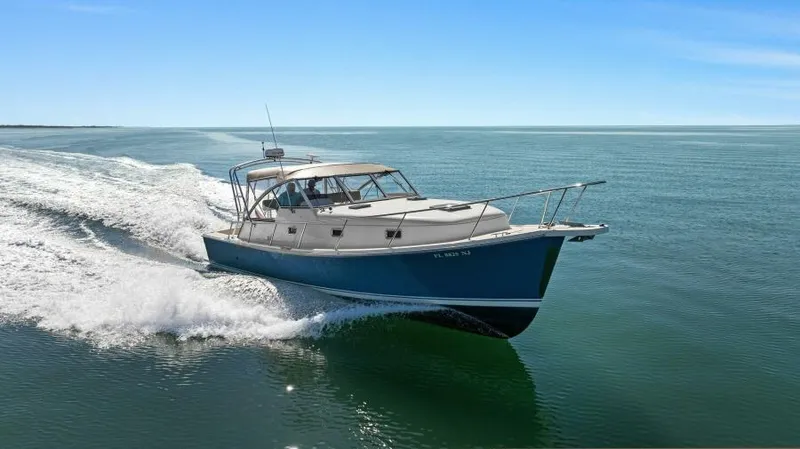 Whattakeeper Yacht Photos Pics 2006 Mainship 34 Rum Runner II cruising on open water under clear blue sky.