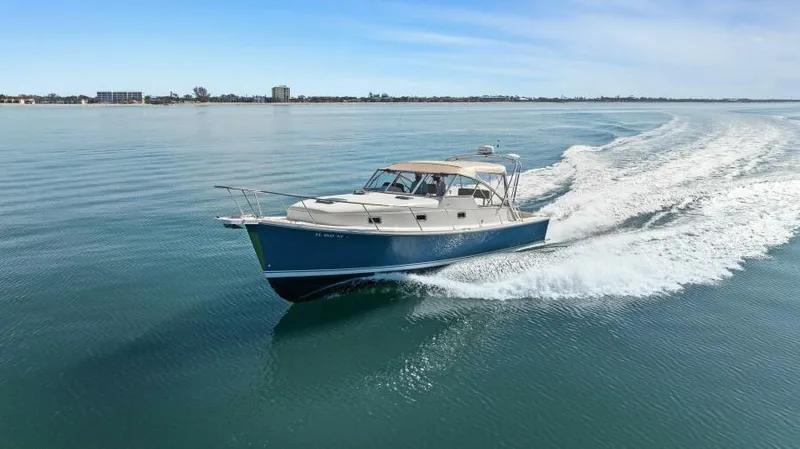 Whattakeeper Yacht Photos Pics 2006 Mainship 34 Rum Runner II cruising on calm waters.