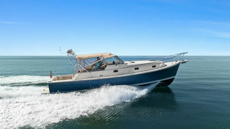 Whattakeeper Yacht Photos Pics 2006 Mainship 34 Rum Runner II cruising on open water under clear blue skies.