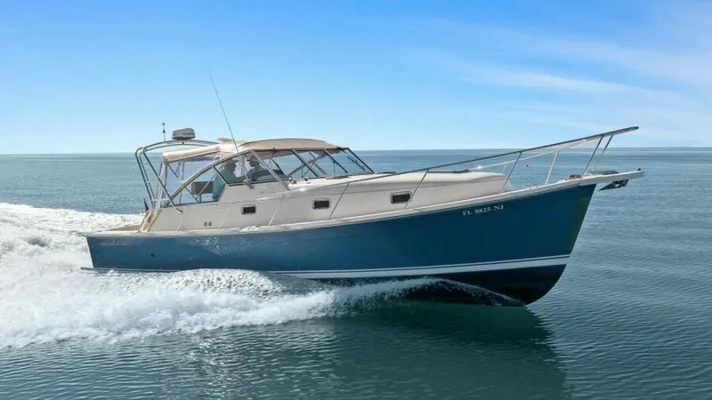 Whattakeeper Yacht Photos Pics 2006 Mainship 34 Rum Runner II cruising on open water under clear blue skies.