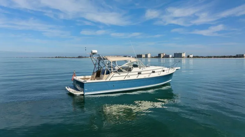 Whattakeeper Yacht Photos Pics 2006 Mainship 34 Rum Runner II cruising on calm waters under a clear blue sky.