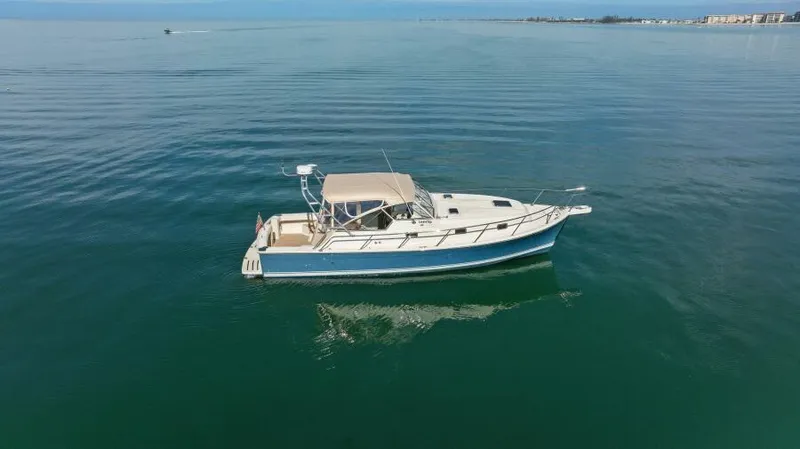 Whattakeeper Yacht Photos Pics 2006 Mainship 34 Rum Runner II cruising on calm waters.