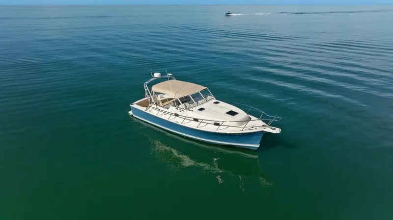 Whattakeeper Yacht Photos Pics 2006 Mainship 34 Rum Runner II cruising on calm ocean waters.