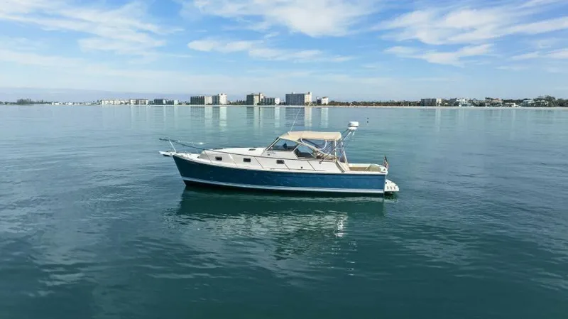 Whattakeeper Yacht Photos Pics 2006 Mainship 34 Rum Runner II cruising on calm waters under a clear sky.