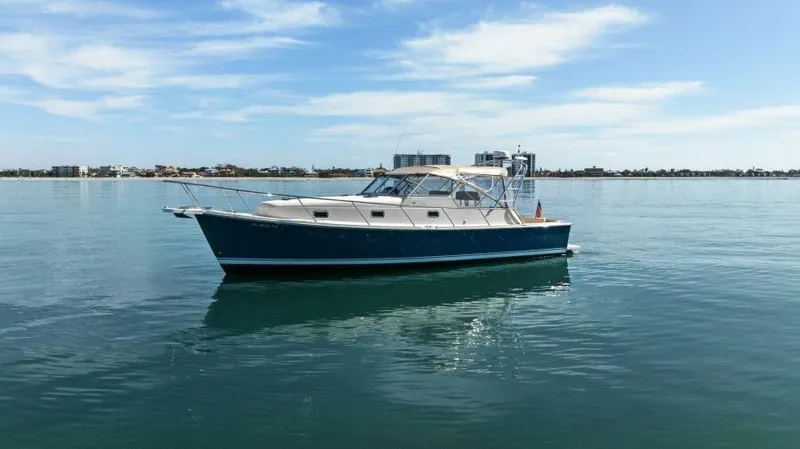 Whattakeeper Yacht Photos Pics 2006 Mainship 34 Rum Runner II cruising on calm waters under a clear sky.