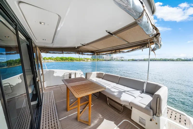 Yacht Photos Pics 2023 Fountaine Pajot MY4.S yacht deck with seating and table, overlooking serene water.