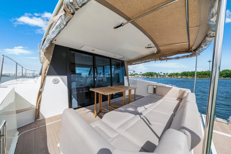  Yacht Photos Pics Luxurious 2023 Fountaine Pajot MY4.S yacht deck with seating and table, overlooking serene waters.