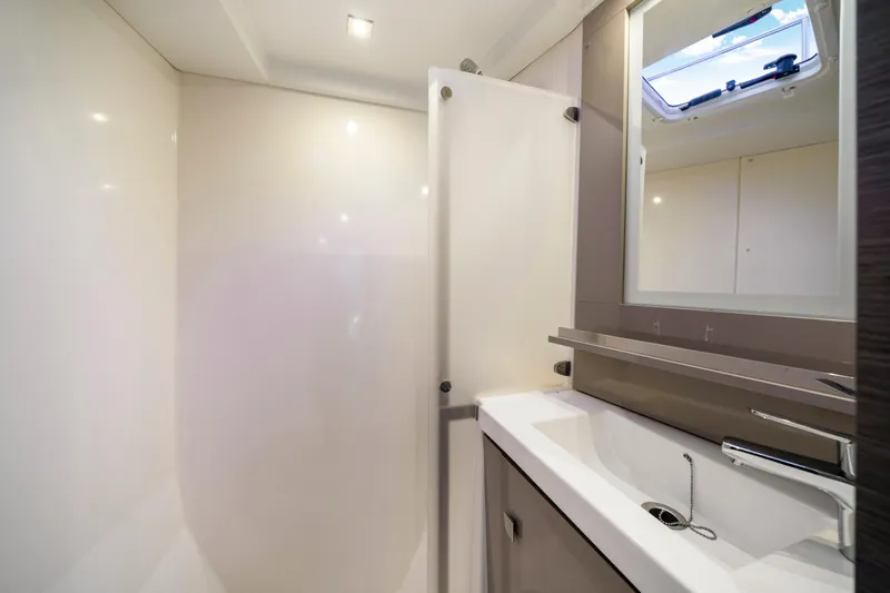  Yacht Photos Pics Modern bathroom interior of 2023 Fountaine Pajot MY4.S yacht, featuring sleek sink and mirror.