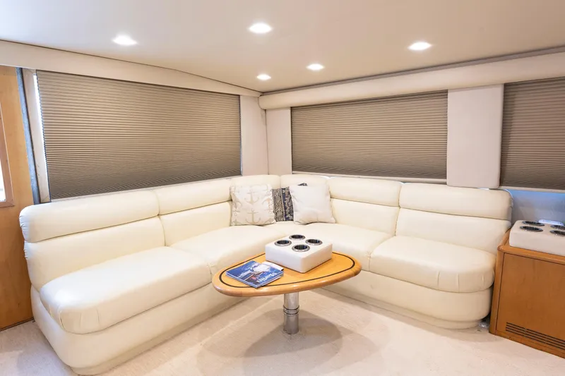 Custom Yacht Photos Pics Luxurious Weaver 61 yacht interior with cream leather seating, wooden table, and modern decor, 2005 model.