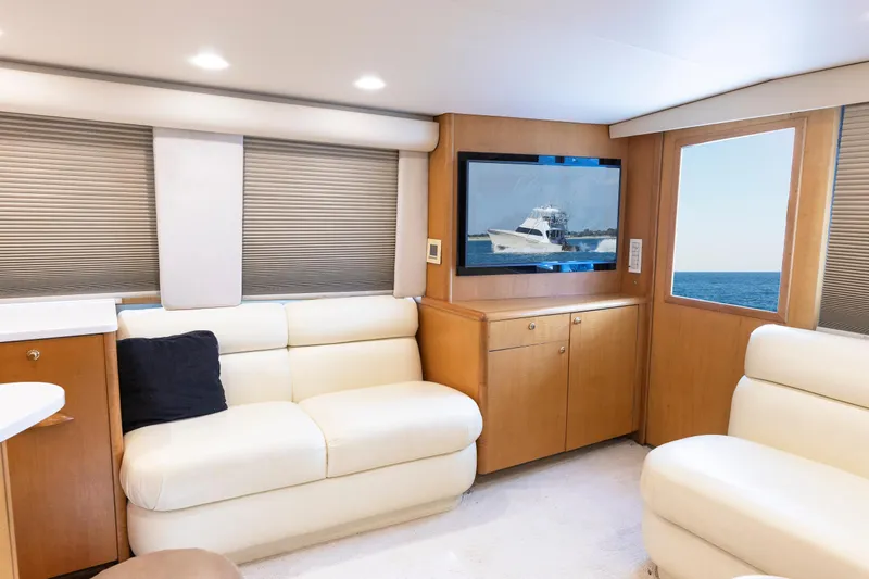 Custom Yacht Photos Pics Luxurious Weaver 61 yacht interior, featuring cream leather seating and a flat-screen TV, 2005 model.