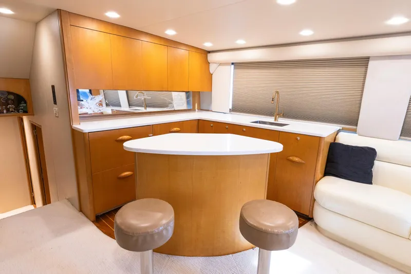 Custom Yacht Photos Pics Luxurious Weaver 61 yacht interior with modern kitchen, bar stools, and elegant wood cabinetry, 2005 model.