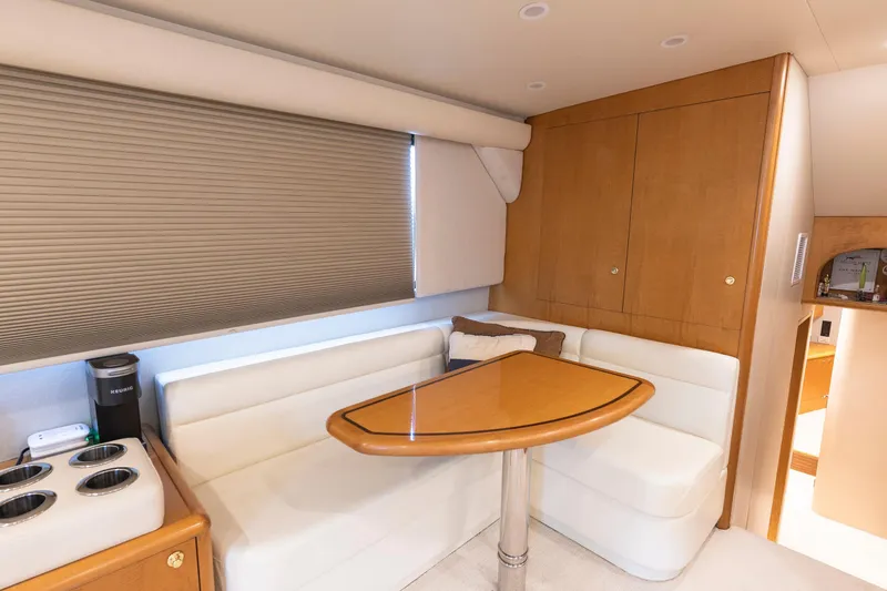 Custom Yacht Photos Pics Cozy dining area in 2005 Weaver 61 yacht with wooden table and white seating.