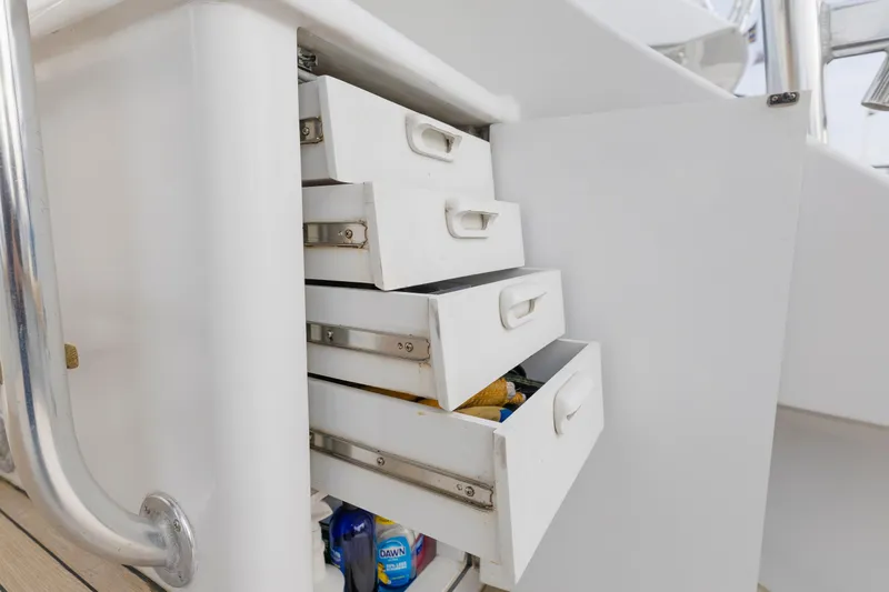Custom Yacht Photos Pics Open white drawers on Weaver 61 boat, revealing cleaning supplies, 2005 model.