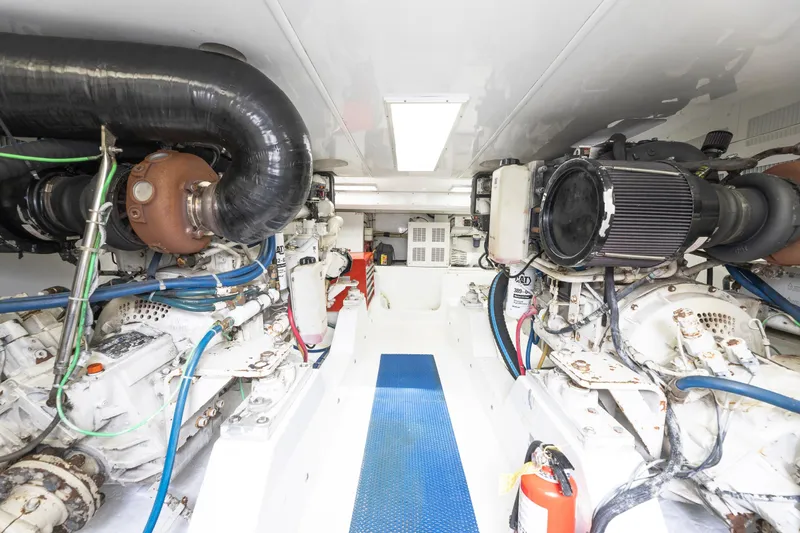 Custom Yacht Photos Pics Engine room of a 2005 Weaver 61 yacht, featuring dual engines and blue piping.