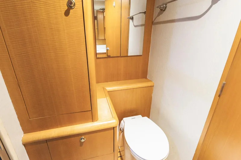 Custom Yacht Photos Pics Wooden bathroom interior on a 2005 Weaver 61 yacht, featuring a toilet and mirror.