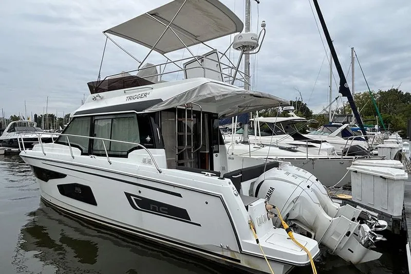  Yacht Photos Pics 2022 Jeanneau NC Weekender 1095 Fly moored at marina, featuring flybridge and outboard engines.