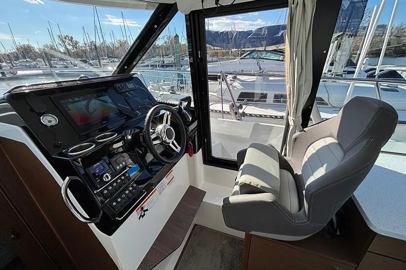  Yacht Photos Pics Interior cockpit of 2022 Jeanneau NC Weekender 1095 Fly with steering wheel and controls.