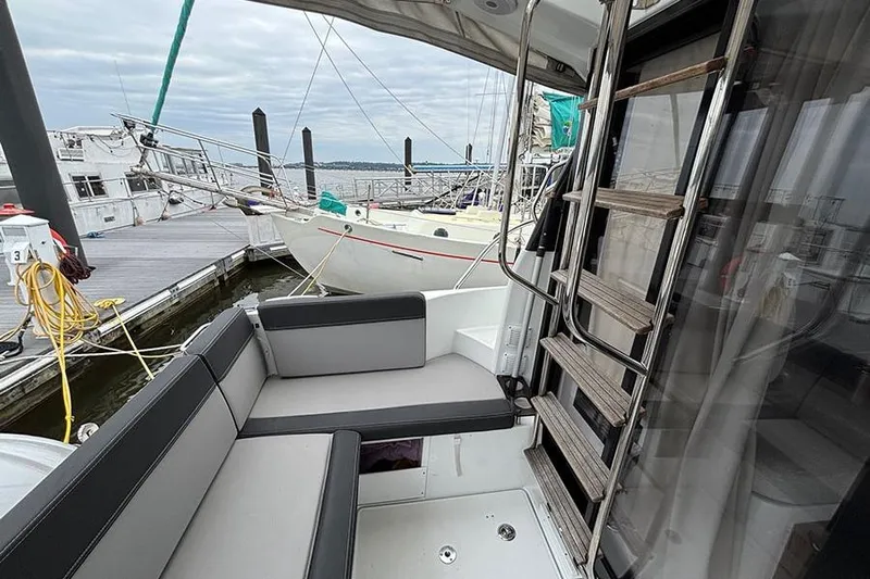  Yacht Photos Pics 2022 Jeanneau NC Weekender 1095 Fly, docked with seating area and ladder.