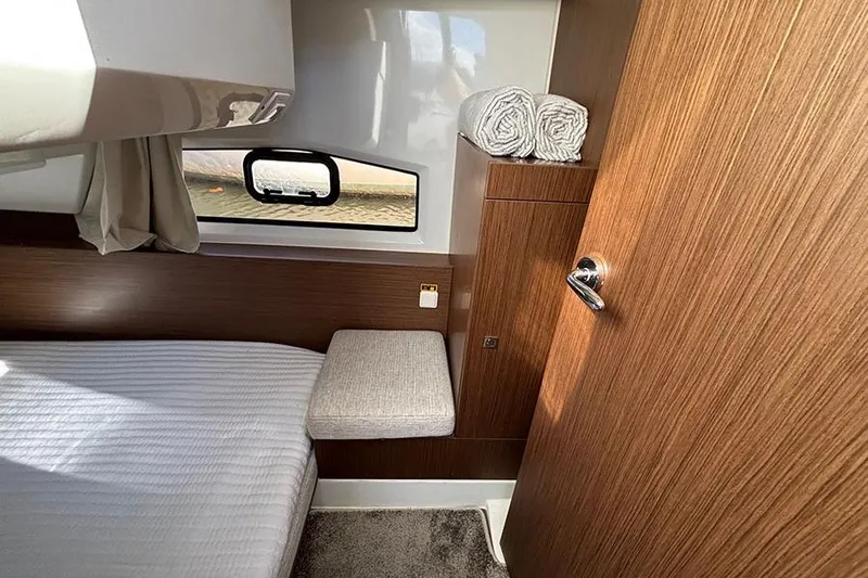  Yacht Photos Pics Cozy cabin interior of 2022 Jeanneau NC Weekender 1095 Fly with wood finish and window.