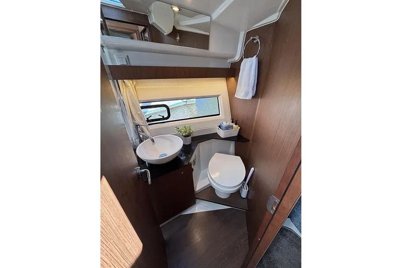  Yacht Photos Pics 2022 Jeanneau NC Weekender 1095 Fly bathroom with modern fixtures and window view.