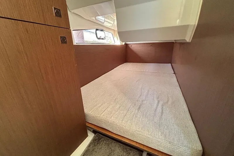  Yacht Photos Pics 2022 Jeanneau NC Weekender 1095 Fly cabin with cozy bed and wooden interior.