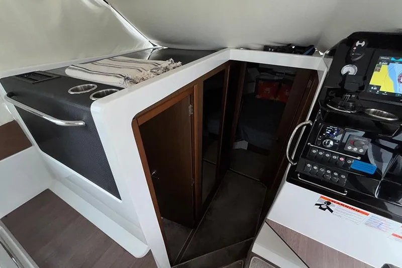  Yacht Photos Pics Interior of 2022 Jeanneau NC Weekender 1095 Fly, featuring helm and cabin entrance.