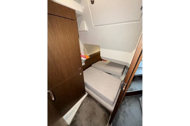  Yacht Photos Pics 2022 Jeanneau NC Weekender 1095 Fly cabin with twin beds and wooden cabinetry.