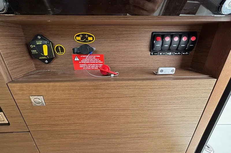  Yacht Photos Pics Control panel of 2022 Jeanneau NC Weekender 1095 Fly with switches and warning labels.