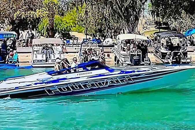 Wasted On You Yacht Photos Pics 2001 Fountain 35 Lightning speedboat on vibrant water, surrounded by people and trees.