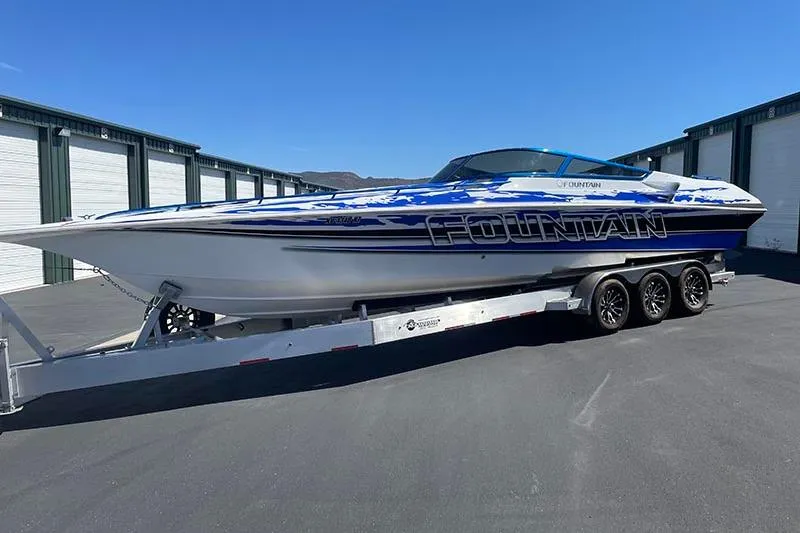 Wasted On You Yacht Photos Pics 2001 Fountain 35 Lightning speedboat on trailer, parked outdoors near storage units.