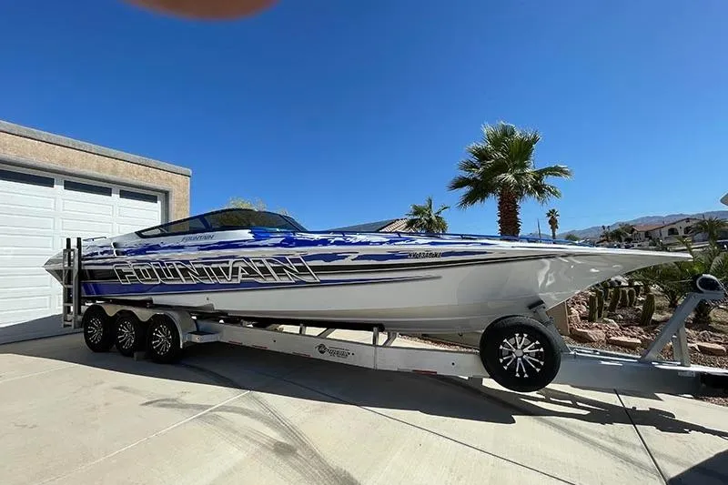 Wasted On You Yacht Photos Pics 2001 Fountain 35 Lightning speedboat on trailer, parked in sunny driveway.
