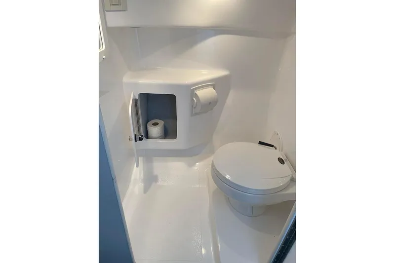 Wasted On You Yacht Photos Pics Compact bathroom in 2001 Fountain 35 Lightning boat, featuring toilet and storage compartment.