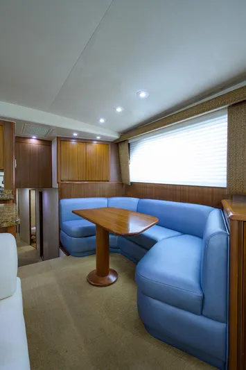  Yacht Photos Pics Luxurious interior of 2005 Viking 61 yacht with blue seating and wooden table.