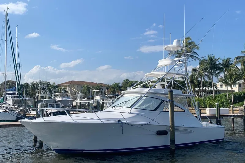 Fluid Power Yacht Photos Pics 2019 Viking 44 Sport Coupe yacht docked in a sunny marina with palm trees.