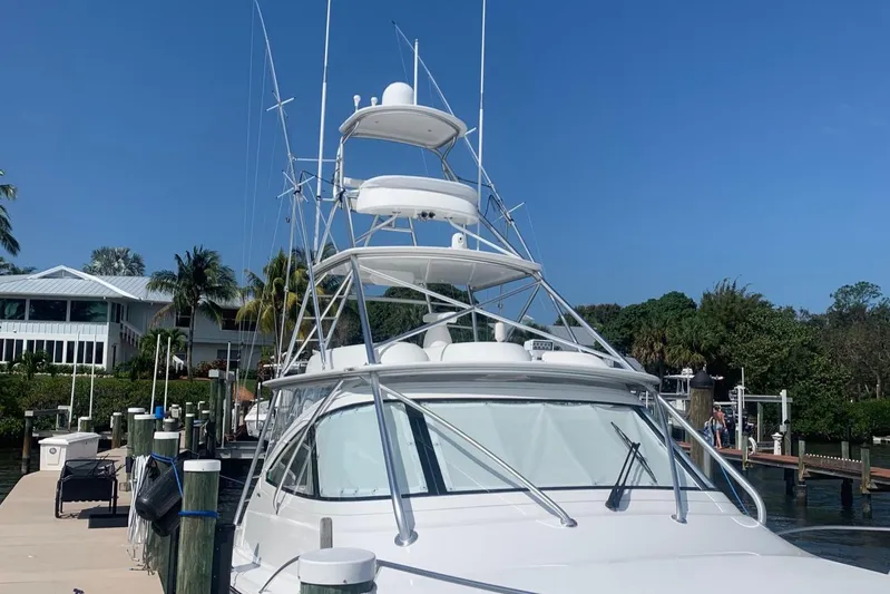 Fluid Power Yacht Photos Pics 2019 Viking 44 Sport Coupe yacht docked at marina under clear blue sky.