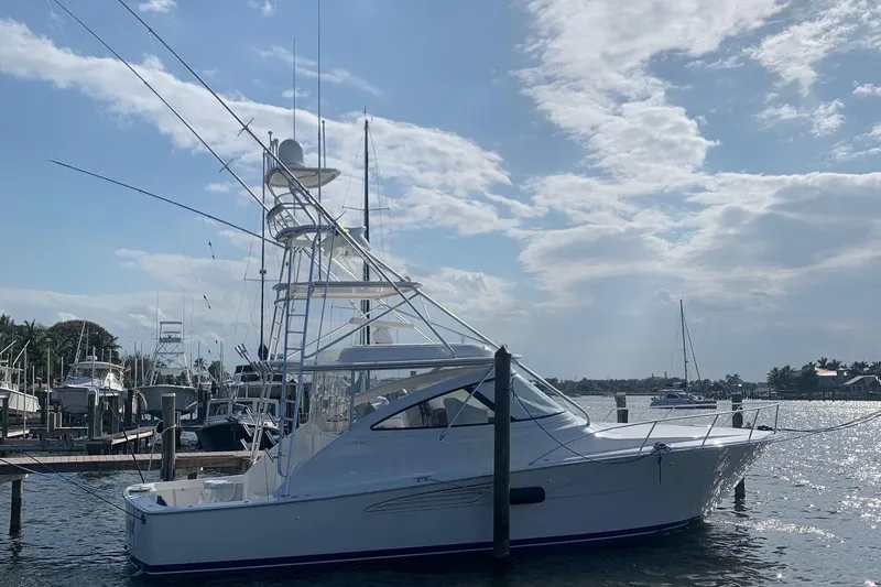 Fluid Power Yacht Photos Pics 2019 Viking 44 Sport Coupe yacht docked under a partly cloudy sky.
