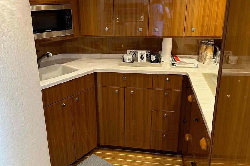 Fluid Power Yacht Photos Pics Luxurious kitchen interior of 2019 Viking 44 Sport Coupe yacht with wood cabinetry.