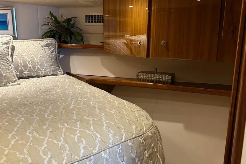 Fluid Power Yacht Photos Pics Luxurious bedroom interior of 2019 Viking 44 Sport Coupe yacht with elegant bedding and wood cabinetry.