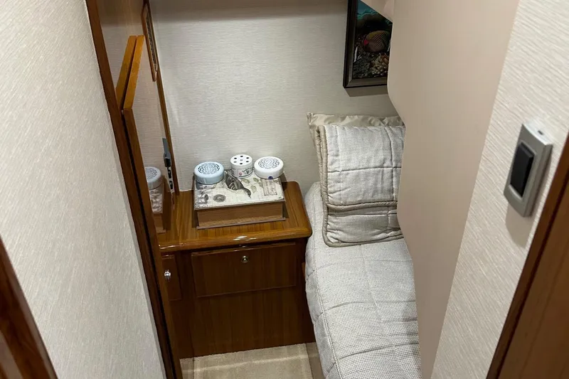 Fluid Power Yacht Photos Pics Small cabin interior of 2019 Viking 44 Sport Coupe with bed and wooden cabinet.