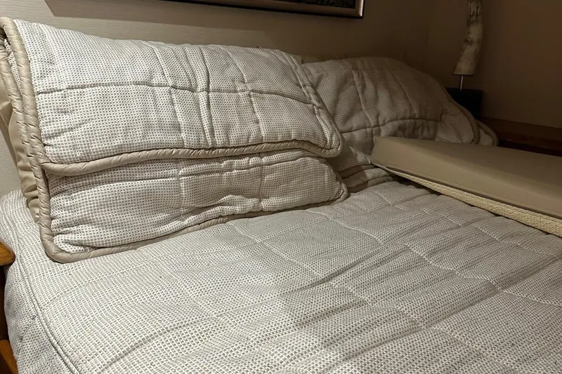 Fluid Power Yacht Photos Pics Luxurious bedding in a 2019 Viking 44 Sport Coupe cabin, featuring plush pillows and a cozy quilt.