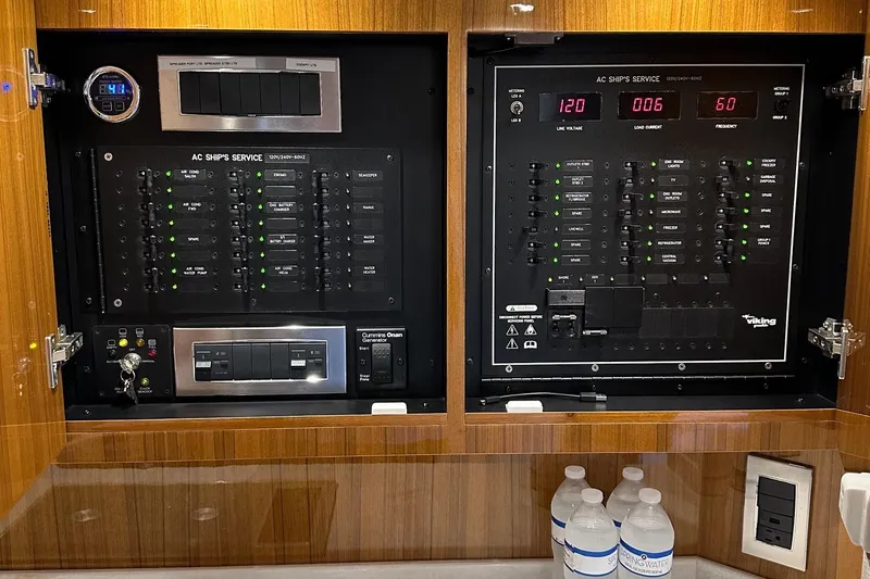 Fluid Power Yacht Photos Pics Electrical control panel of a 2019 Viking 44 Sport Coupe yacht with water bottles below.